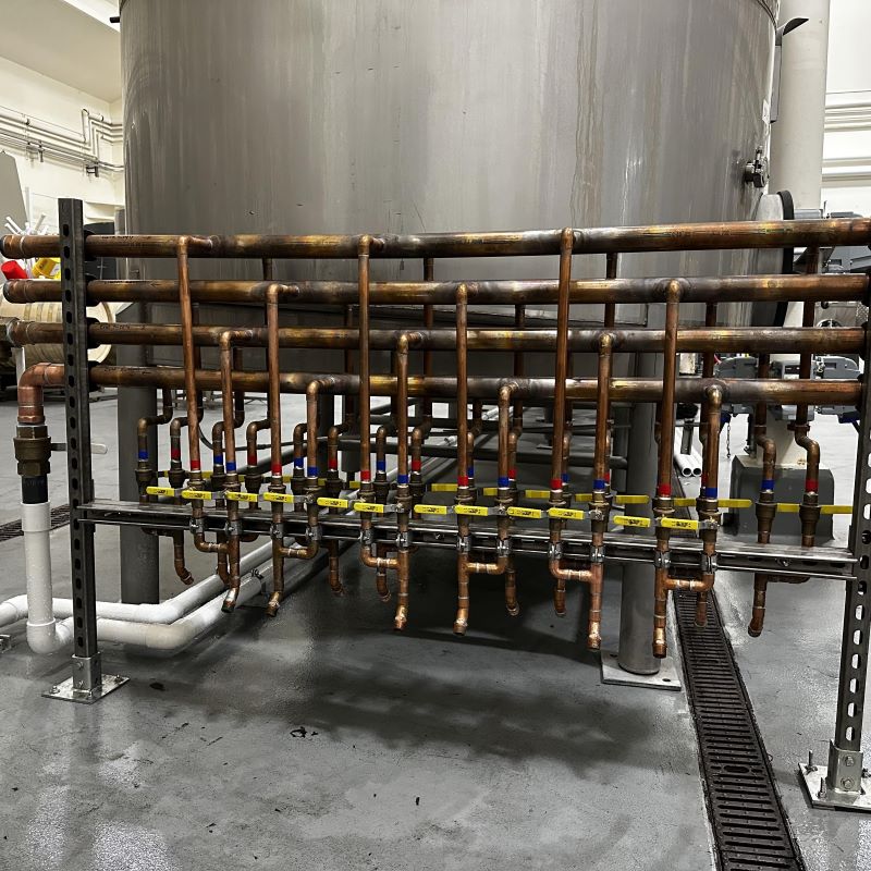 Custom-fabricated copper manifold and valve cluster system for brewery and winery process line integration.