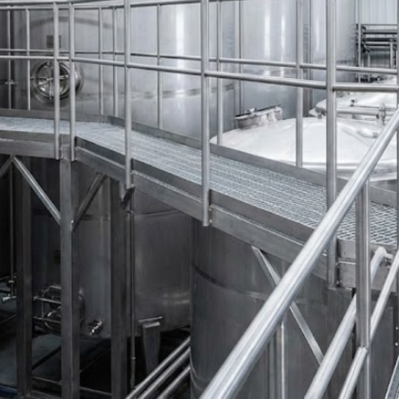 Custom fabricated metal catwalk and safety platform for elevated worker access to industrial winery tanks in Napa County.